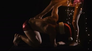 Naked body. Beautiful sexy Santa Clause in elegant panties, stockings and bra. Fashion portrait of model girl indoors with christmas tree. Cute woman in lace red lingerie. Female ass in underwear.