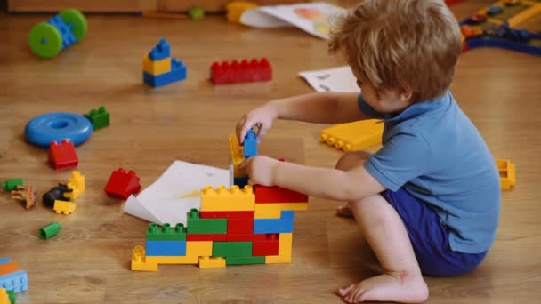 Development and construction concept. Kids play room. Child playing building blocks toys — Stock Video