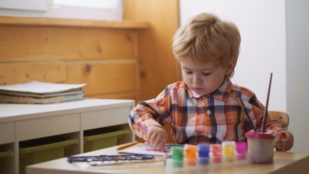 Dibujo. Concepto de creatividad y educación. Feliz chico lindo colorea sus manos. Haciendo pintura de dedos. Terapia artística para niños. Psicología de la personalidad infantil. — Vídeo de stock