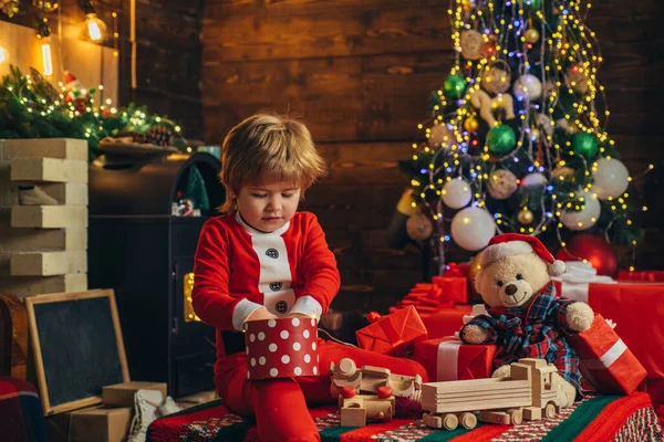 Criança feliz decorar árvore de Natal. Modelos criança se divertindo com o presente. Criança com dom. Na manhã anterior ao Natal. As crianças gostam do feriado. — Fotografia de Stock