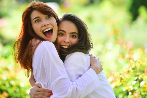 Vacaciones de mujeres jóvenes felices. Caminan afuera. Abrázense y mírense. Sonríe y disfruta de la vida. Chica enamorada. — Foto de Stock