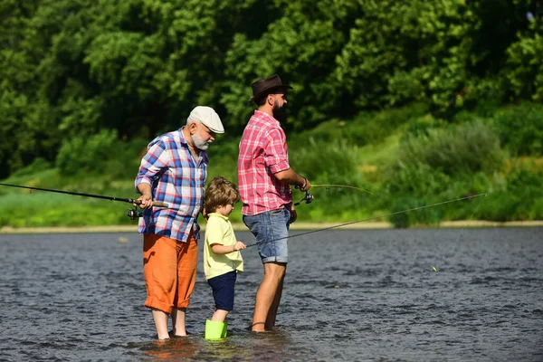 Fly Fishing. Little boy fly fishing on a lake with his father and grandfather.