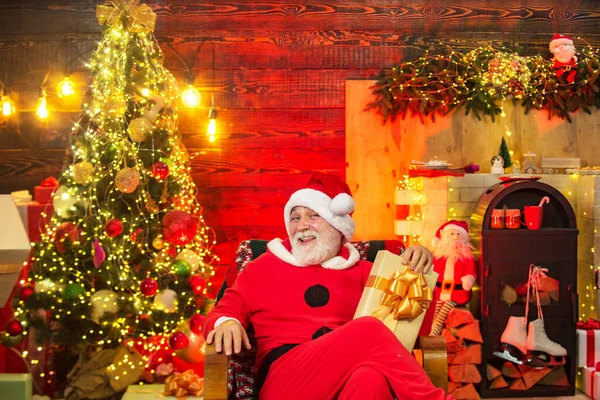 Preparazione natalizia - Babbo Natale che celebra il nuovo anno. Santa nonno con una barba bianca in posa sullo sfondo di legno di Natale. — Foto Stock