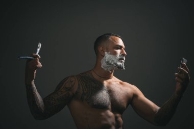 Eski ahşap arka planda fotokopi alanı olan berber aletleri. Berber dükkanı. Şık erkek sakalı portresi. Kuaför makas ve tarakla saç stili ve stili yapıyor. İnce Kesikler.