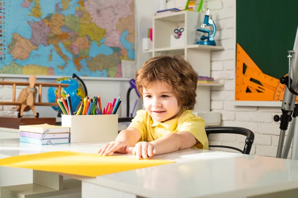 Kinderen maken zich klaar voor school. Kind in de buurt van schoolbord in de klas. Onderwijsproces. — Stockfoto