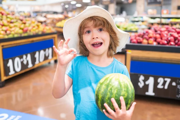 Porträtt av barn hålla vattenmelon i mataffären shopping i snabbköpet, Begreppet shopping, hälsosam mat, sälja och köpa. — Stockfoto