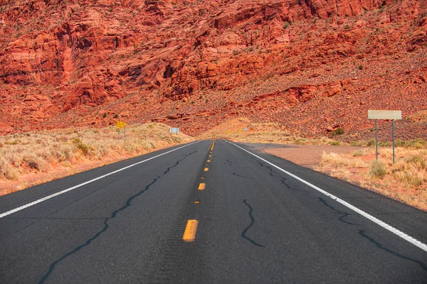 Paesaggio con rocce, cielo soleggiato con nuvole e bella strada asfaltata la sera in estate. Strada asfaltata negli Stati Uniti. — Foto Stock