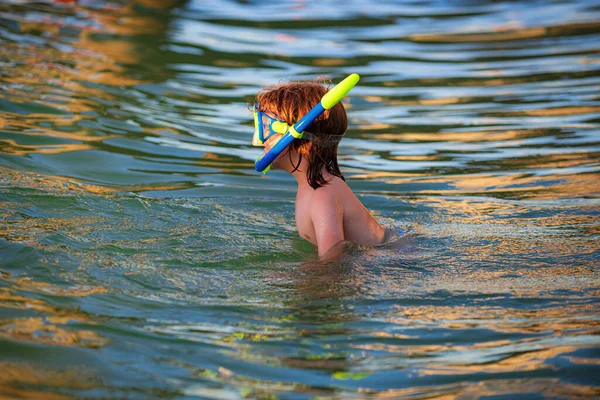 Pojken leker på stranden på sommarlovet. Glada barn som simmar i havet. Kid snorkling i havet. — Stockfoto
