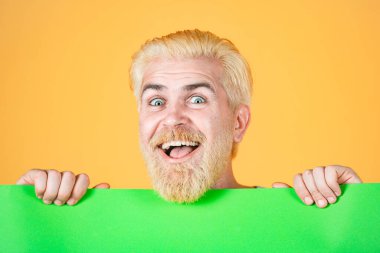 Gülümseyen adam açık yeşil kağıt gösteriyor. Boş beyaz tahta tutan mutlu adam..