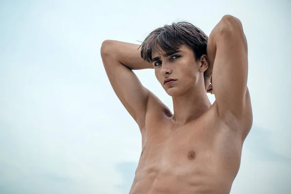 Красивый сексуальный молодой человек. Портрет без рубашки мускулистый человек стоит на фоне неба и смотрит в камеру. — стоковое фото