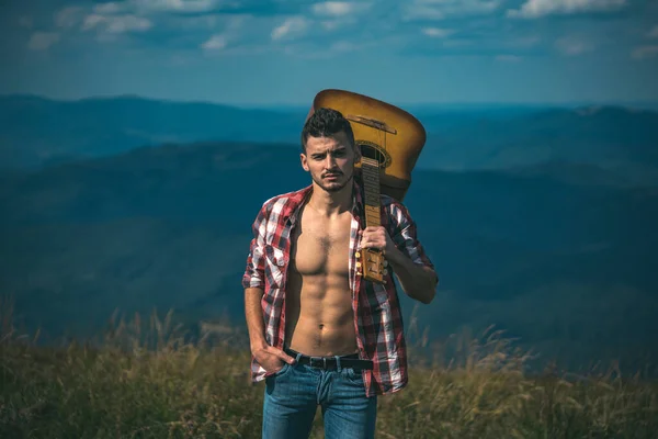 Caminante. Senderista motivado con guitarra mirando a la hermosa vista. Trekking, viajes y concepto turístico. Fitness y estilo de vida saludable. Hombre casual, estilo de vida. — Foto de Stock