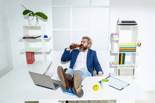 Sıkıcı sarhoş işadamı iş günü sonunda ofiste. Bir şişe alkollü sarhoş iş adamı. Sarhoş bir ofis çalışanı, rastgele bir şişe bira taşıyor.. — Stok fotoğraf