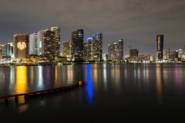 Miami Sunset Panorama 'sı. Biscayne Körfezi' nde renkli iş yerleri ve konut binaları ve köprü. Biscayne Körfezi 'ndeki Miami silueti, şehir gece arkaplanı..