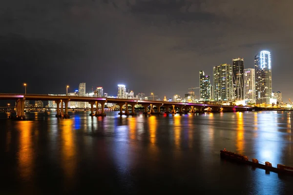 Miami Florida, naplemente panoráma színes megvilágított üzleti és lakóépületek és híd Biscayne Bay. Miami belvárosa. — Stock Fotó