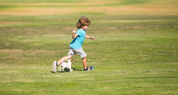 Perro que corre. Niño feliz correr con un perro al aire libre. —  Fotos de Stock