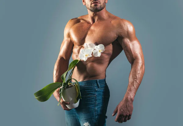 軽薄な運動裸の男は蘭を保持する。インポテンツの概念。人間の力. — ストック写真