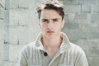 Gri duvara karşı şık bir genç adam. Biçim ve eğilim.