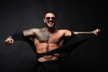 Kızgın adam gömleğini yırttı. Çıplak gövdeli kaslı seksi adam..
