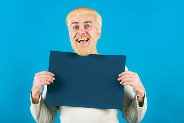 Молодой человек показывает лист бумаги в камере на цветном фоне. Буклет дизайн листа отображения читать от первого лица. — стоковое фото
