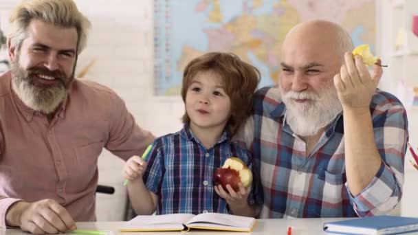 Privatschüler. Glücklicher Vater, Großvater und Sohn beim Lernen. Glückliches, nettes, fleißiges Kind sitzt drinnen an einem Schreibtisch. Individueller Unterricht. — Stockvideo