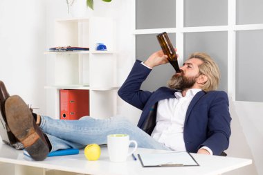 Bağımsız hipster, ofis çalışanı, iş adamı son teslim tarihinden önce işi bitiren, iş gününün sarhoş sonu. İşadamı masa başında içki içiyor..