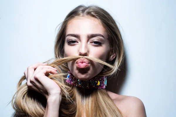 Een jonge vrouw die een snor met haar haar maakt. Prachtig verleidelijk model meisje met lang haar. Schoonheidsmeisje, mooie blonde vrouwen haar. — Stockfoto