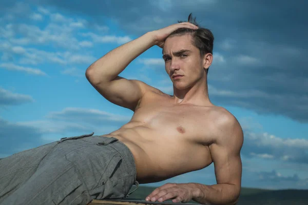 Sexy torso desnudo masculino. Atlético joven mostrando su cuerpo desnudo perfecto al aire libre. — Foto de Stock