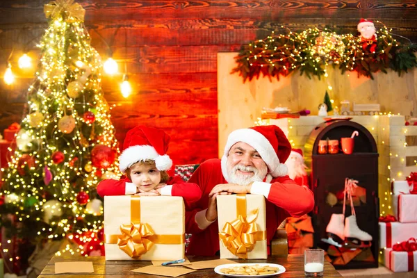 Criança de Natal. Surpreendido Pai Natal na sala de Natal. Papai Noel ajudante e avô com presentes. Acredite no milagre de Natal. — Fotografia de Stock