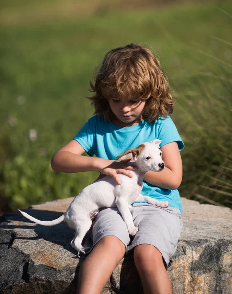 Enfant mignon avec un chien chiot, été en plein air. — Photo