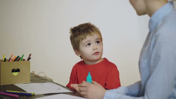 Barnehagebarn på barneskolen. Mor tegner med liten sønn. – stockvideo