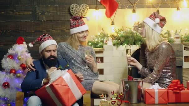 Gruppera vänner med julklappslådor framför julgranen. Rolig grupp glada unga människor. Skäggig hipster med flickvänner firar nyårsafton. — Stockvideo