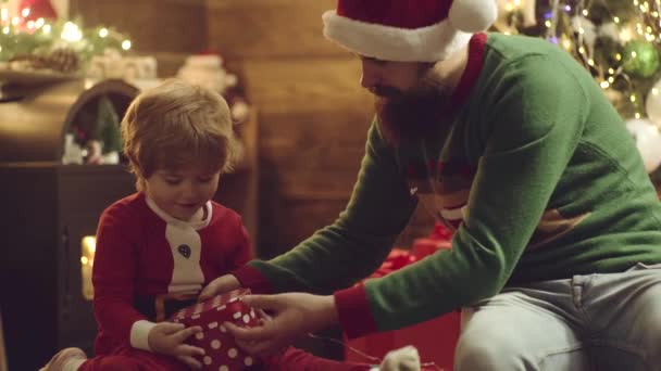 Crianças pequenas felizes com pai em chapéu de Papai Noel presente aberto e ter um Natal. Dia de Ação de Graças e Ano Novo. — Vídeo de Stock