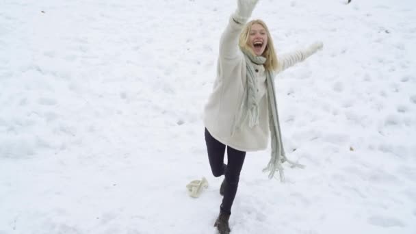 Menina adolescente pulando e jogando uma bola de neve. Jovem mulher jogando bola de neve luta no inverno. Menina no jogo bolas de neve. Modelo de inverno feminino se divertindo no parque nevado. — Vídeo de Stock