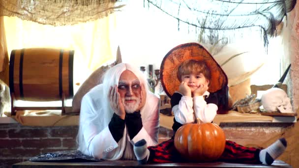 Diavolo carino con cappello da strega in posa con zucca su sfondo Halloween. Halloween a casa. — Video Stock