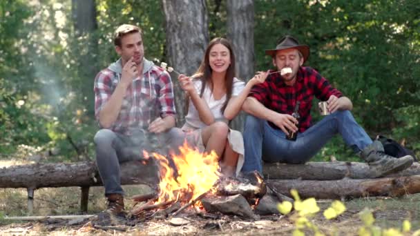 Estilo de vida. Empresa que tiene caminata picnic naturaleza fondo. Amigos asando perritos calientes en palos en la hoguera y divirtiéndose en el fuego del campamento. Amigos de la compañía pasan un gran día de campo cerca de la hoguera. — Vídeos de Stock