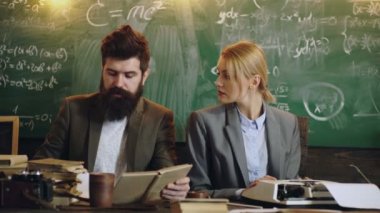 Üniversite profesörü ders veriyor ve masa başında duruyor..