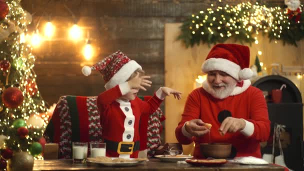 Weihnachtsmänner mit Enkelkindern bereiten Weihnachten oder Neujahr in der Weihnachtsmütze vor, backen zu Hause Weihnachtsplätzchen. Frohe Weihnachten. — Stockvideo