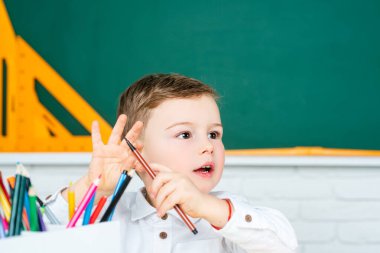 Arka planda tahtası olan bir çocuk sınıfın içinde. Okula geri dön..