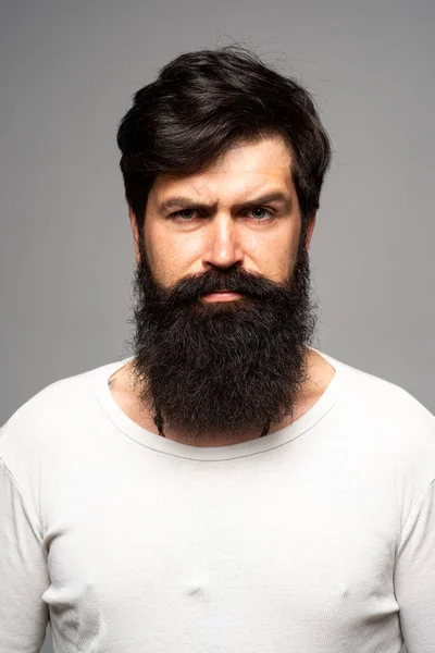 Retrato de homem sério confiante tem barba e bigode, olha a sério, isolado. Pensando cara barbudo elegante. — Fotografia de Stock