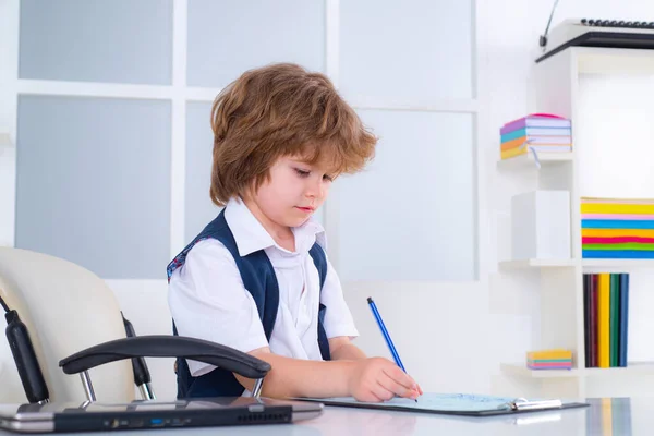 Portret van een kleine jongen aan zijn bureau in het kantoor. Kinderzakenman aan zijn bureau. Saaie baan. Jonge zakenman.. — Stockfoto