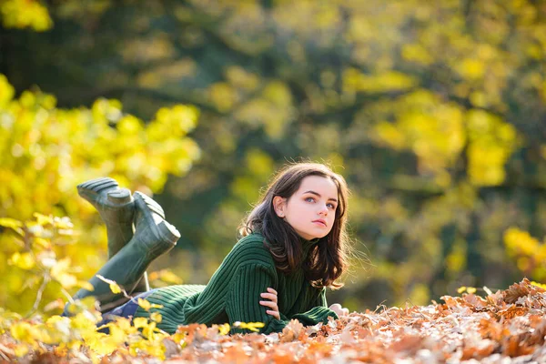 Roztomilá dospívající dívka ležící na podzimním javorovém listí na podzim venku. Krásný podzimní čas v přírodě. — Stock fotografie