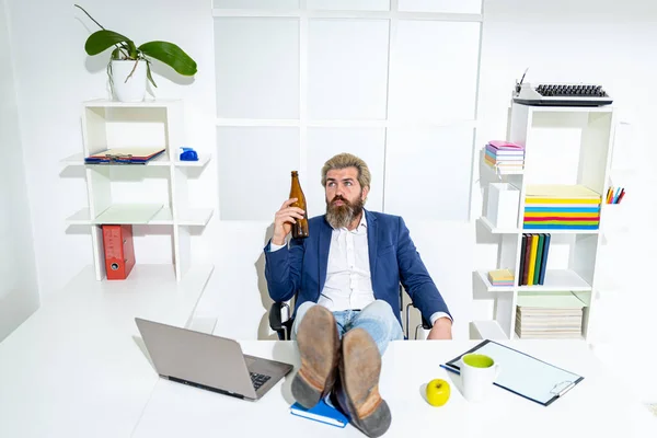 Haksız yere işten çıkarılma konusunda umutsuz bir ofis çalışanı. Sıkı çalışmadan sonra. İş adamı elinde bira şişesi tutuyor.. — Stok fotoğraf