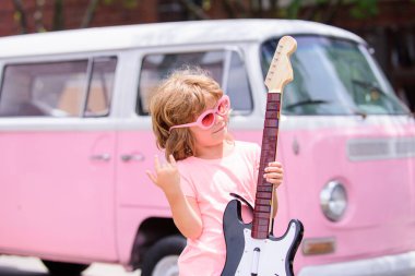 Beyaz çocuk gitar çalmayı öğreniyor. Rock yıldızı çocuklar.