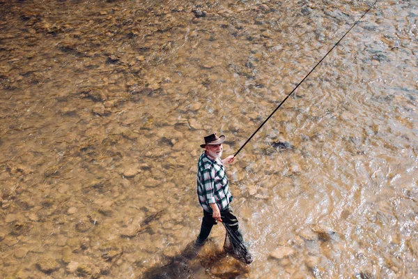 Homem maduro pescando no lago. Feliz pesca com mosca. Angler a apanhar o peixe. Mestre Baiter. Captura e pesca. Fuga rural. Dar o seu hobby. — Fotografia de Stock