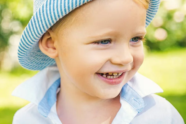 Kindergezicht. Portret van een vrolijk lachend kind op de achtergrond van de natuur. Kind buiten spelen. Grappig jongetje. — Stockfoto