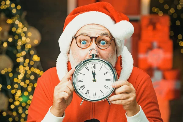 Frohes neues Jahr. Der Weihnachtsmann mit echtem Bart hält die Uhr. Frohe Weihnachten Weihnachtsmann mit Uhr. Foto vom Weihnachtsmann, der auf die Uhr zeigt, die fünf Minuten vor Mitternacht zeigt. — Stockfoto