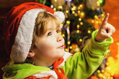 Çocuk şirin neşeli çocuk Noel ağacının yanında oyun oynuyor. Kış tatilleri için şöminenin yanında hediyeler. Noel arifesi. Noel arifesinde Noel ağacı ve şömine başında bir çocuk..