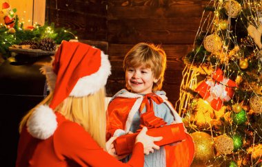 Noel Baba şapkalı anne sevgili oğluyla oynuyor. Yeni yıl hediyesi. Kış tatili Alışveriş satışı. Noel 'i birlikte kutluyoruz. Mutlu yıllar. Tatil indirimleri.