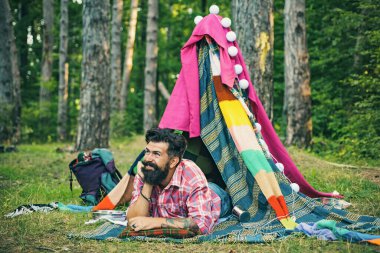 Aktif insanlar. Kamp çadırındaki yakışıklı sakallı adam. Erkekler için rahat bir oyun çadırı. Dalların kulübesi. Dinlenme kampı.