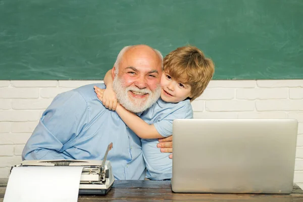 Przytul się i uściskaj. Portret dziadka i wnuka podczas pracy w klasie szkolnej nad zieloną tablicą. Wracając do koncepcji szkoły i edukacji. Nauczyciel i dziecko. — Zdjęcie stockowe